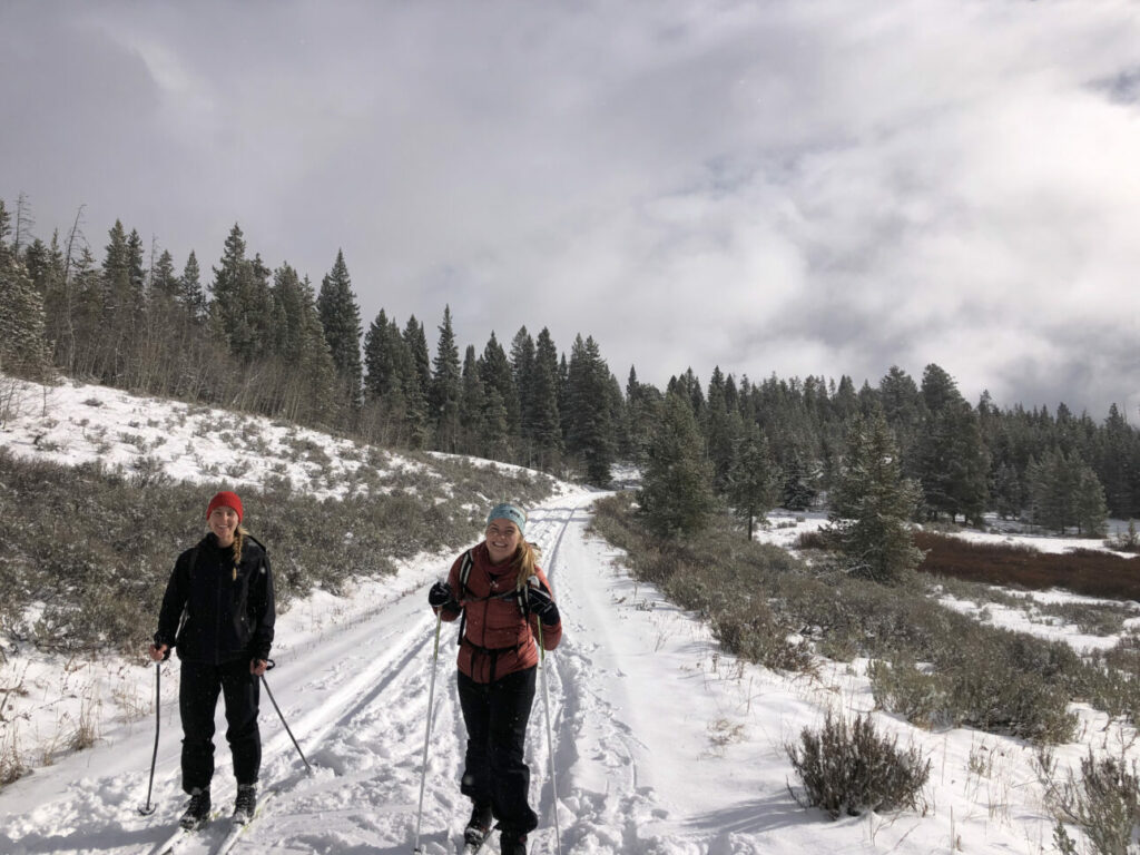 Two Gen Z Nordic skiers smiling on the Nordic trail