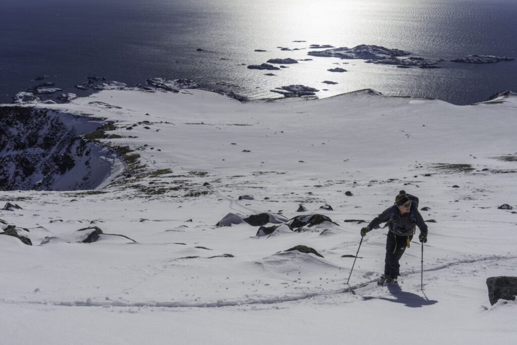 A scenic view of mountains and Jim Roscoe, nordic ski luminary, skiing along tracks in Finland