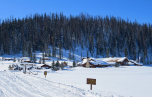 a cozy lodge covered with snow next to winter trails