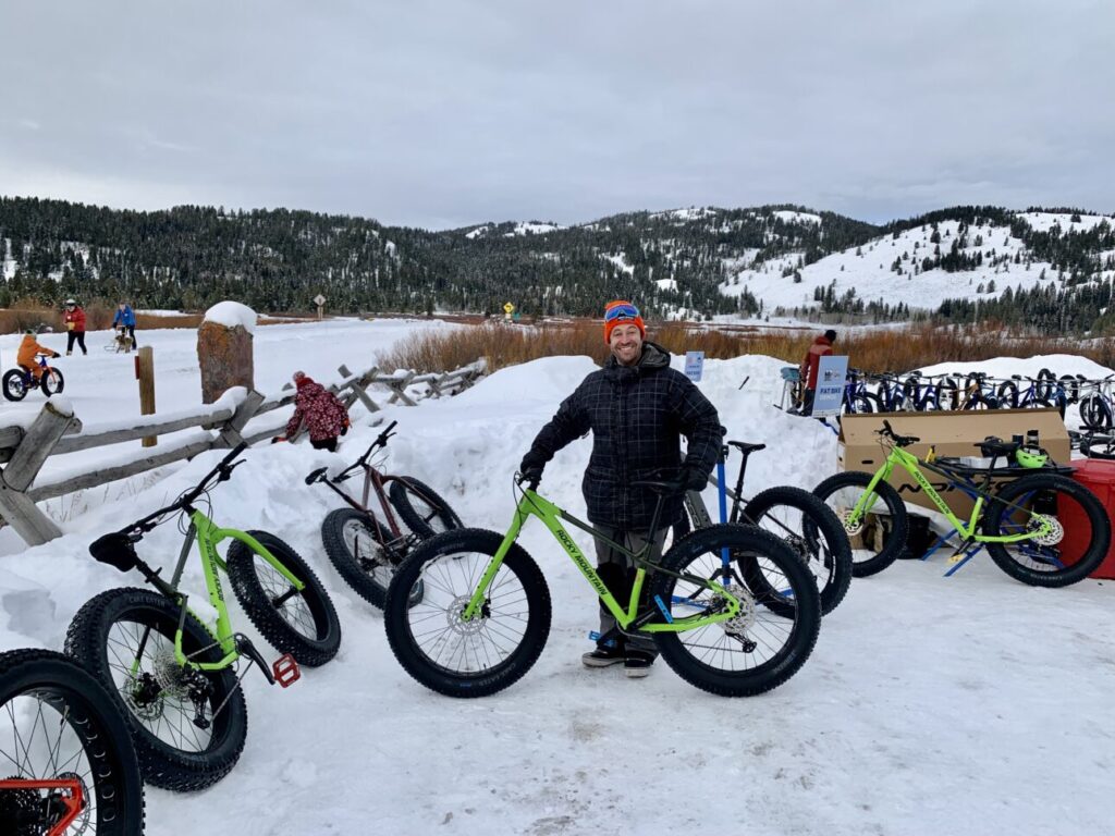Winter recreation enthusiast poses by a fatbike