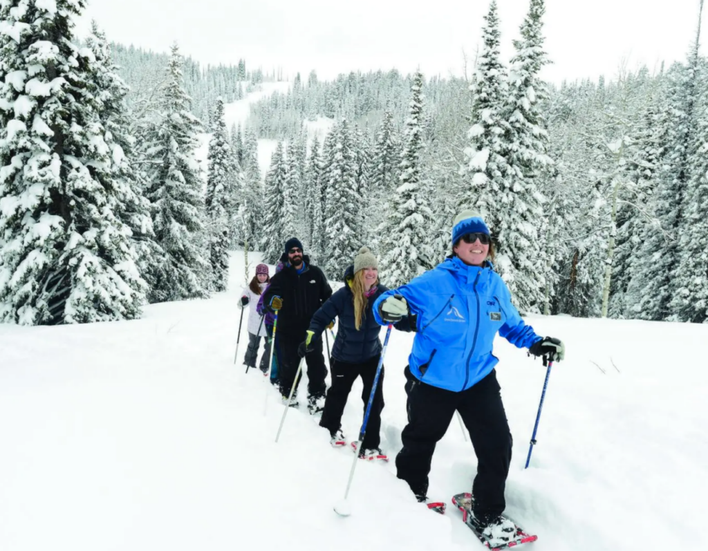 A group snowshoes in a National Forest 