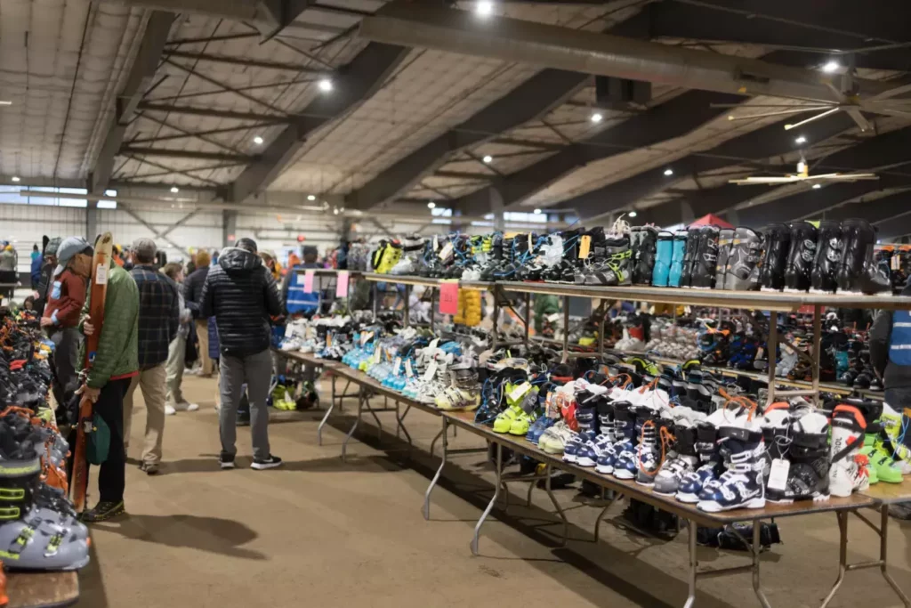 rows of used ski boots for sale lined up for the ski swap