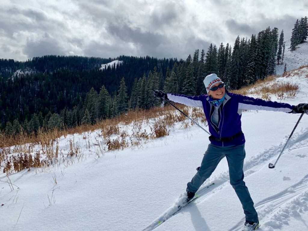 woman excited to be on her first nordic ski of the season on early-season snow
