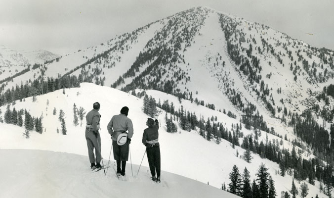 A vintage black and white photo of Betty Woolsey and two others from a ski hill