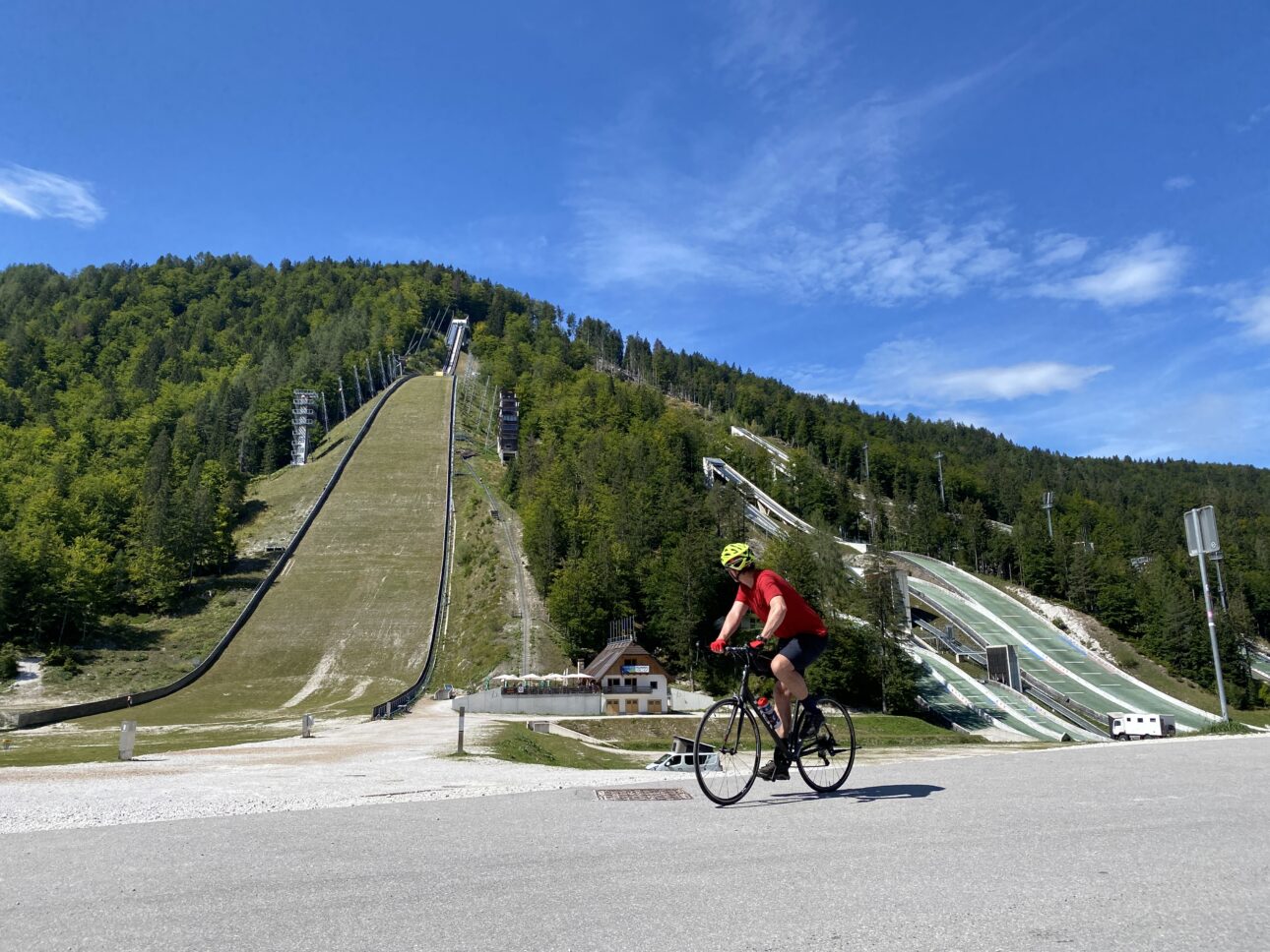 Author's Husband, Chris Harder, rides by the ski jumping area after ascending the hill into Planica