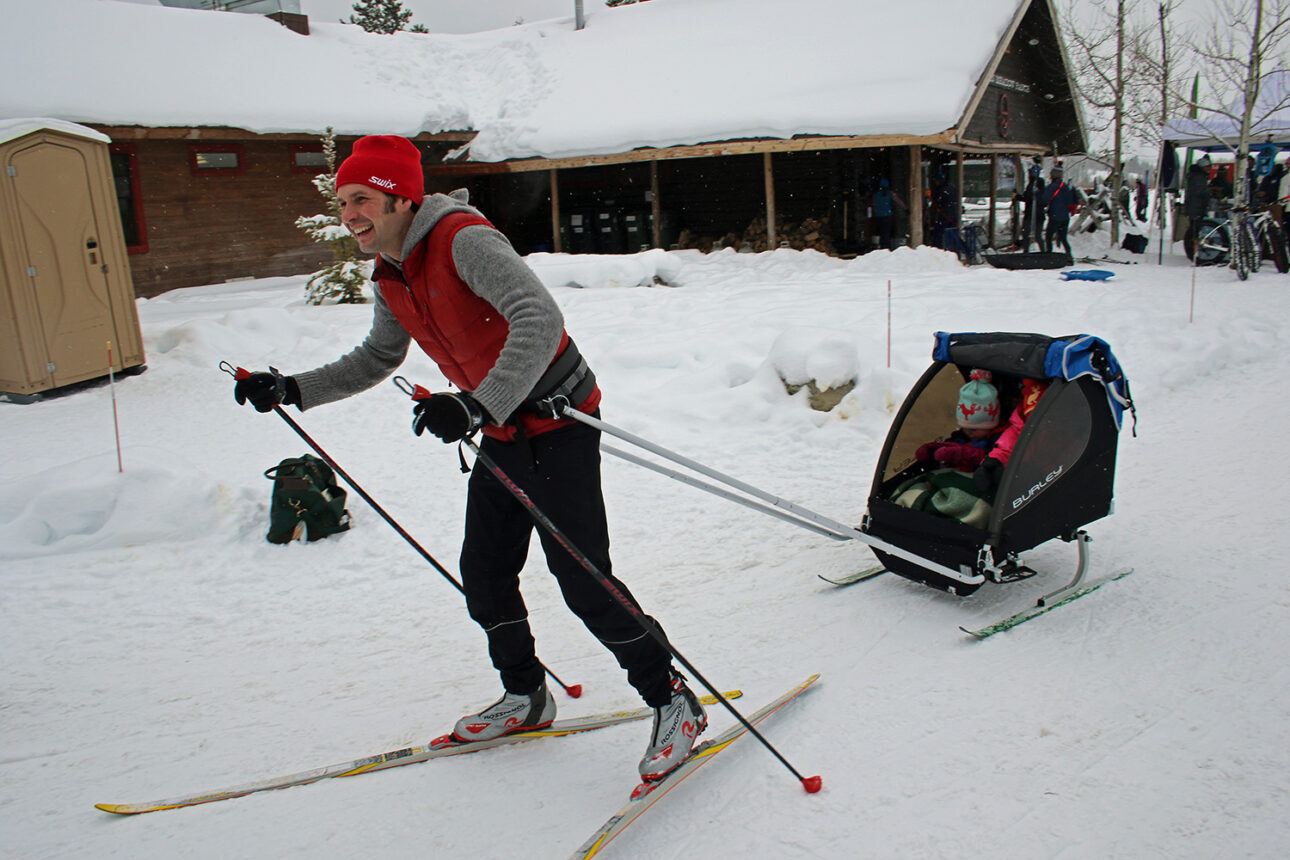 Father towing his kids in a chariot