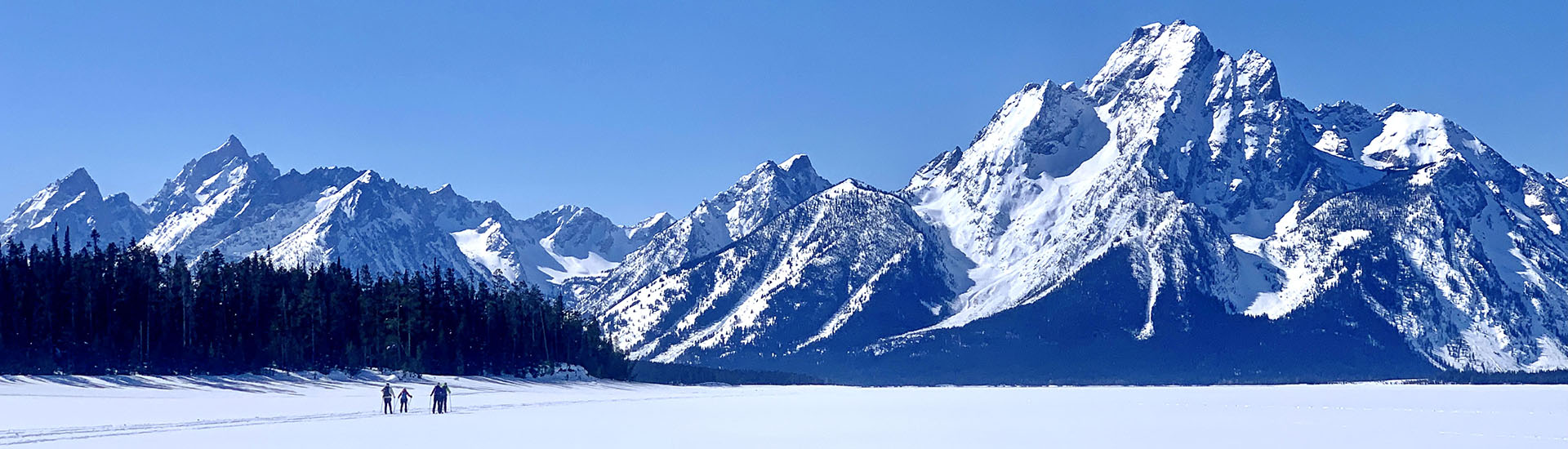 cross country skiiers on Jackson Lake with Mt. Moran